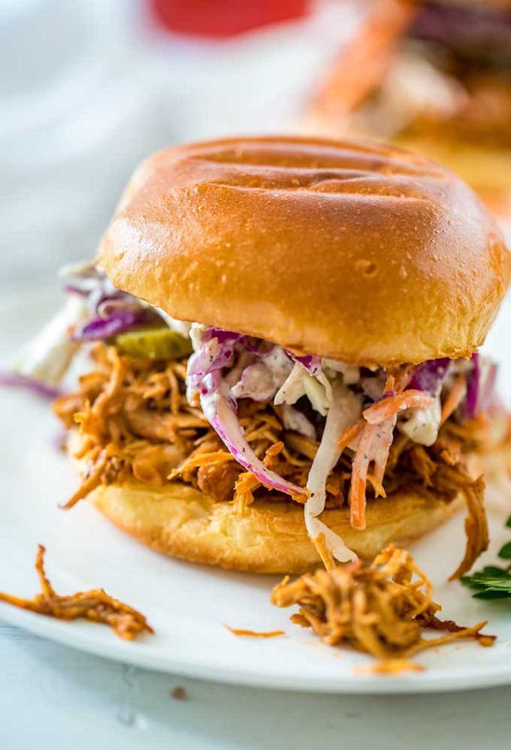 a pulled pork sandwich on a white plate