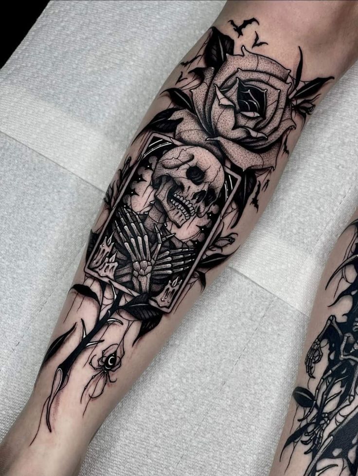 a couple of legs with tattoos on them and one has a skull in the middle