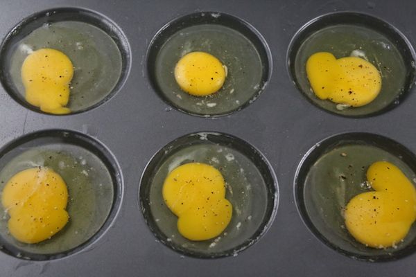 six eggs are in the middle of a muffin tin