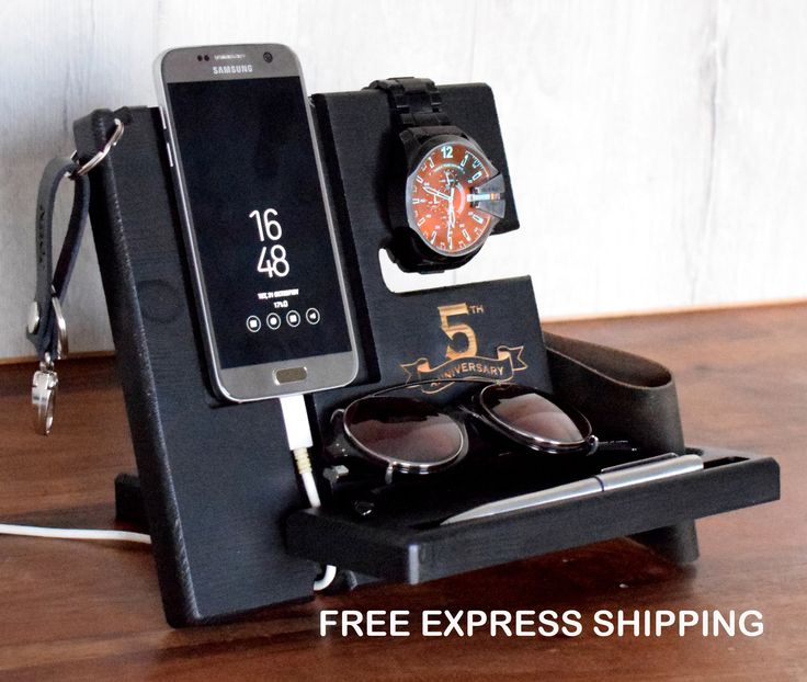 a cell phone, watch and sunglasses in a holder