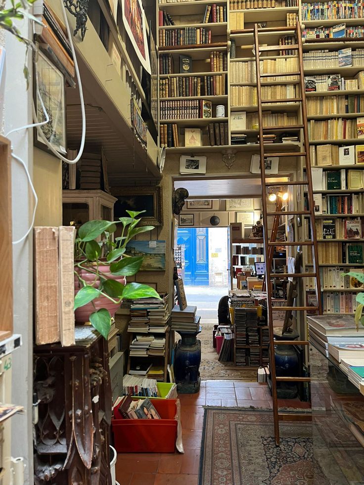 a room filled with lots of books next to a tall wooden book shelf full of books