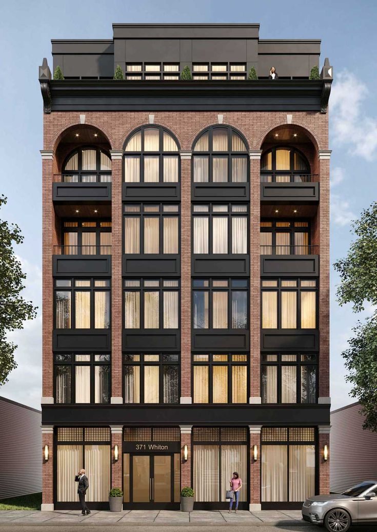 an apartment building with lots of windows and people standing in the doorways next to it