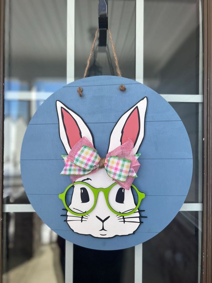 a blue sign with a bunny wearing glasses and a bow on it's head