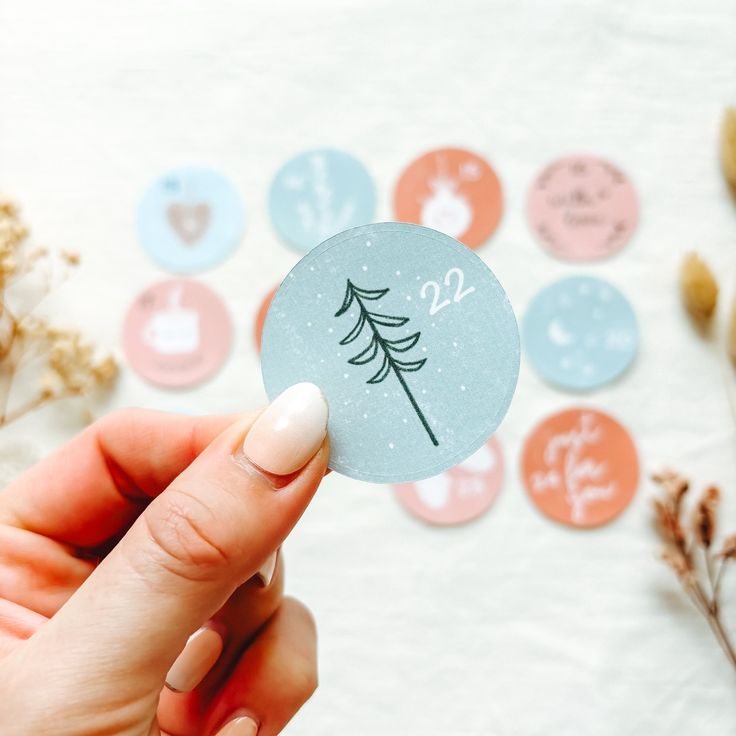 a person holding up a sticker with the number twenty two on it, surrounded by flowers