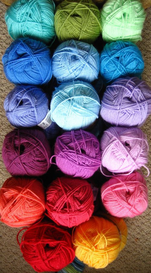 several balls of yarn are stacked on top of each other in different colors and sizes