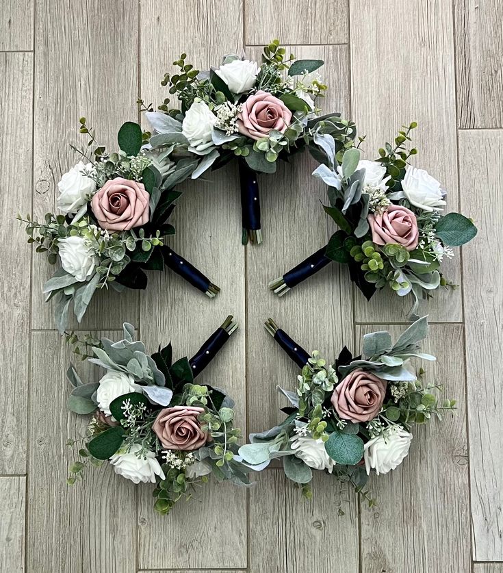 a flower arrangement arranged in the shape of a wreath on a wooden floor with scissors