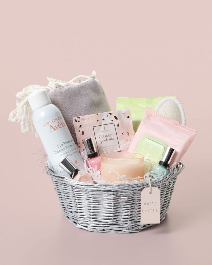 a basket filled with personal care items on top of a white table next to a bottle of lotion