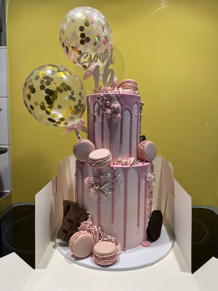 a three tiered cake with balloons and confetti