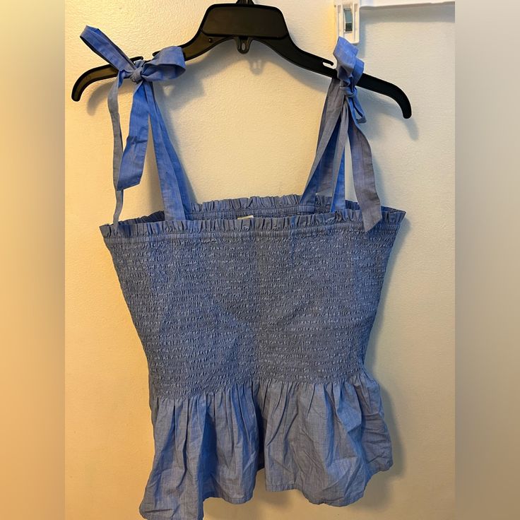 Missed Return Window. Tie Strap, Chambray, Smocked Top With Short Peplum. Perfect For The Summer. My Loss Is Your Gain! Beach Cotton Tank Top With Smocked Back, Cotton Tank Top With Smocked Back For Beach, Cotton Tank Top With Smocked Bodice For Vacation, Casual Cami Top With Smocked Bodice, Beach Smocked Cami Top, Beach Cami Top With Smocked Bodice, Beach Smocked Bodice Cami Top, Blue Summer Top With Smocked Back, Sleeveless Cotton Top With Smocked Back