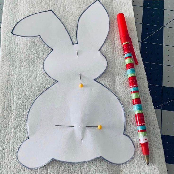 a piece of paper cut out to look like a bunny with a pencil next to it