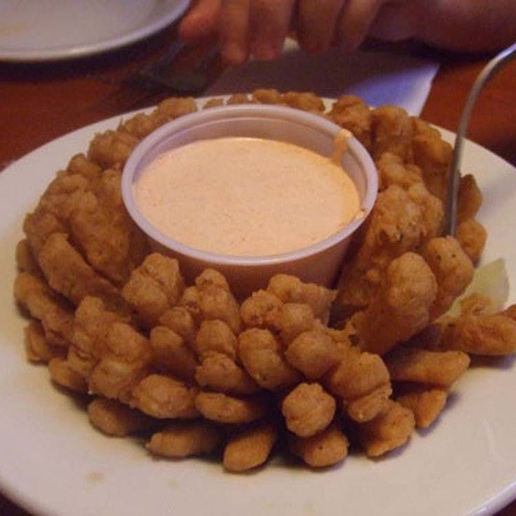 a white plate topped with tater tots and dipping sauce