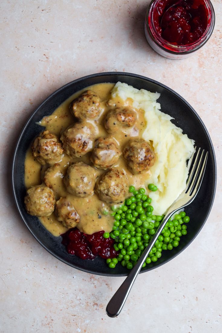 a plate with meatballs, mashed potatoes and peas