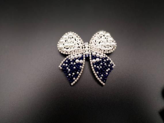 White Decorative Bow Jewelry For Wedding, White Jewelry With Decorative Bow For Wedding, Elegant Blue Beaded Brooches, White Wedding Jewelry With Decorative Bow, Elegant Blue Wedding Brooches, Silver Bow Brooch For Wedding, White Rhinestone Brooches For Formal Occasions, White Crystal Brooch With Rhinestones, Formal White Brooches With Rhinestones