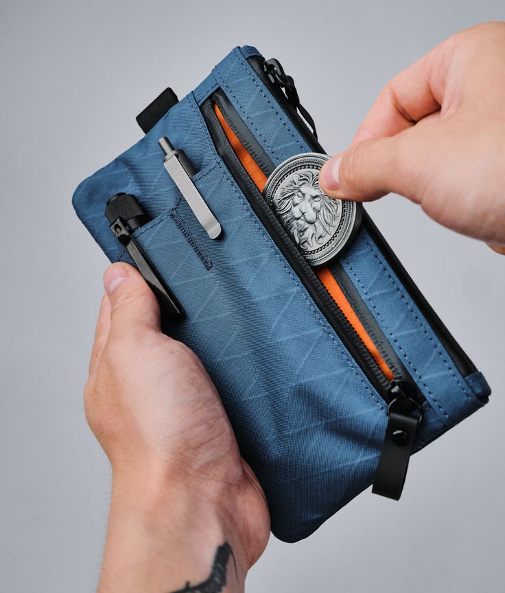 a person holding an open wallet with scissors in it