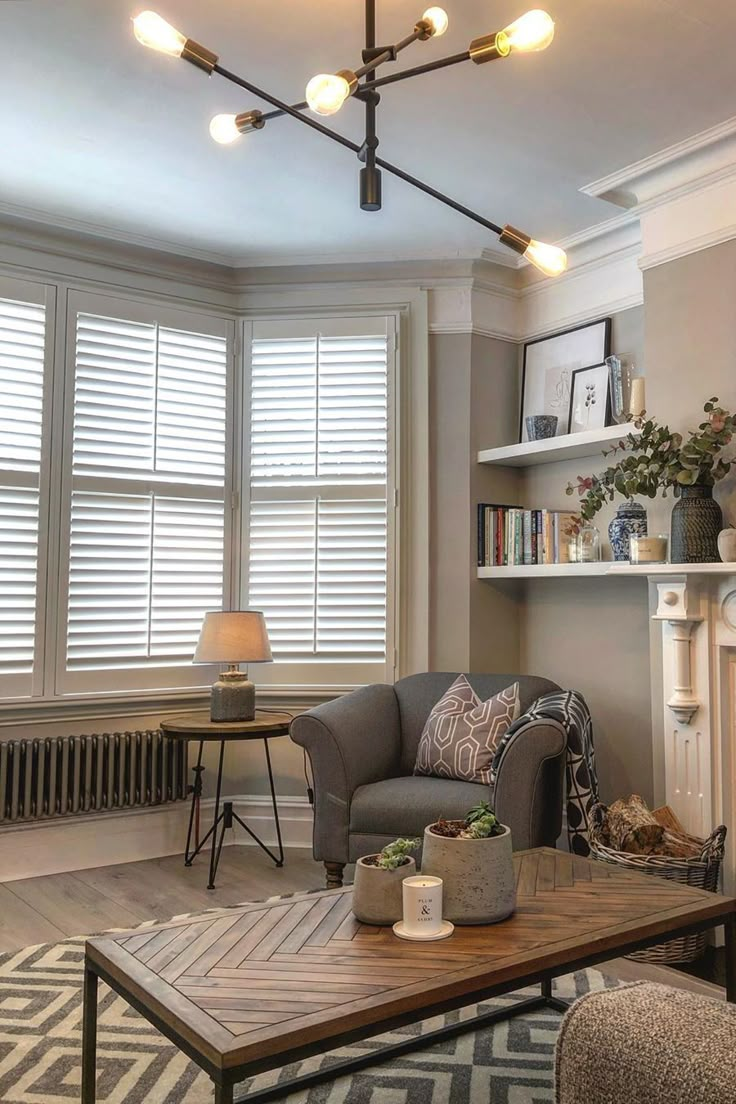 a living room filled with furniture and a fire place in front of a window covered in blinds