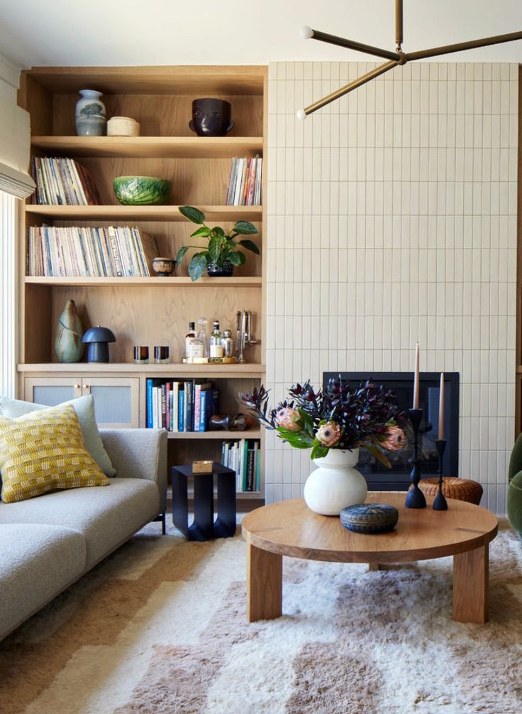 a living room filled with furniture and bookshelves next to a fire burning place