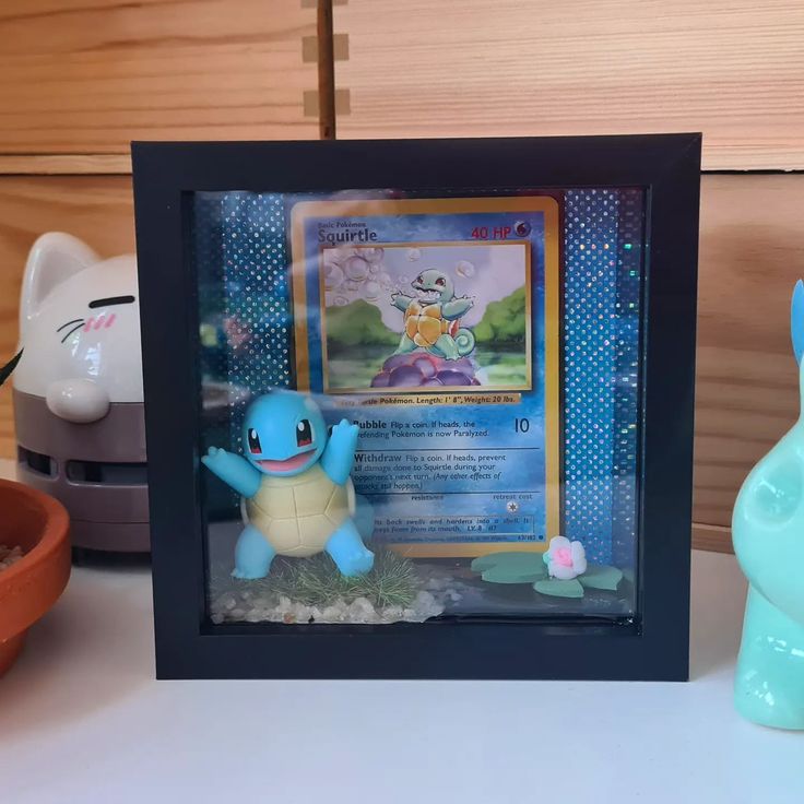 a pokemon figurine is sitting next to a photo frame