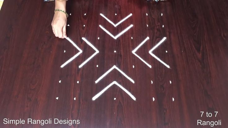 a person standing on top of a wooden floor next to a table with arrows drawn on it