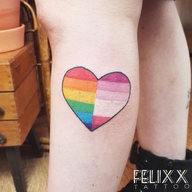 a woman's leg with a rainbow heart tattoo on it