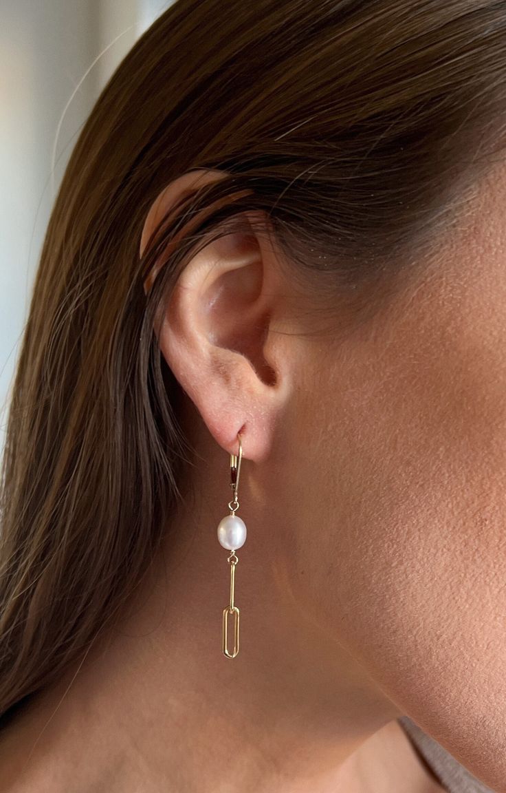 Infuse contemporary elegance into your jewelry collection with our Pearl and Paperclip Chain Leverback Earrings. Perfectly blending the timeless allure of genuine freshwater pearls with the trendy touch of a paperclip chain, these earrings are a stylish update to a classic accessory. The secure leverback ear wires offer both comfort and reliability, while the earrings' drop length provides a subtle yet alluring dangle. These versatile and chic earrings are ideal for everyday sophistication or adding a special sparkle to your evening ensemble. Features: - Crafted with genuine freshwater pearls for a touch of classic beauty. - Trendy paperclip chain design adds a chic twist to traditional pearl earrings. - Secure leverback ear wires for comfort and peace of mind throughout the day. - Perfect Modern 14k Gold Drop Earrings, Modern 14k Gold Teardrop Jewelry, Everyday Yellow Gold Pierced Pearl Earrings, Modern Dangle Earrings With Pearl Drop, Timeless Dangle Jewelry With Matching Earrings, White Modern Pierced Pearl Earrings, Minimalist Drop Earrings For Formal Occasions, Modern White Pierced Pearl Earrings, Modern Jewelry With Matching Earrings For Anniversary