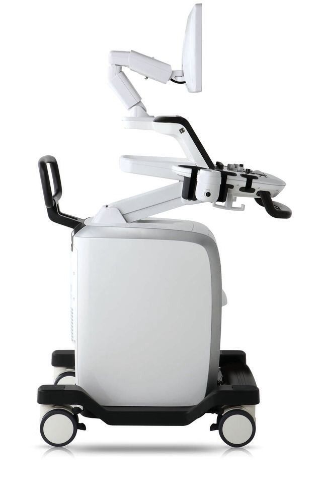 an image of a medical device with wheels on the back and armrests attached to it