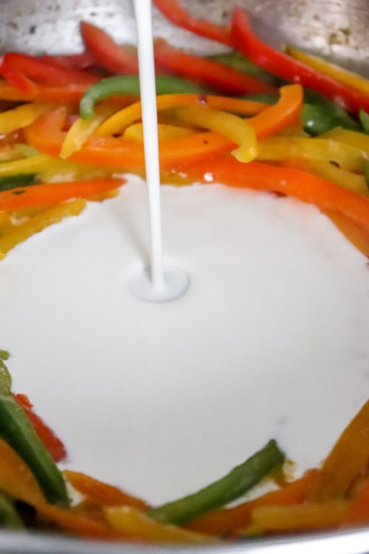 stir frying vegetables in a pan with a white spatula sticking out of the top