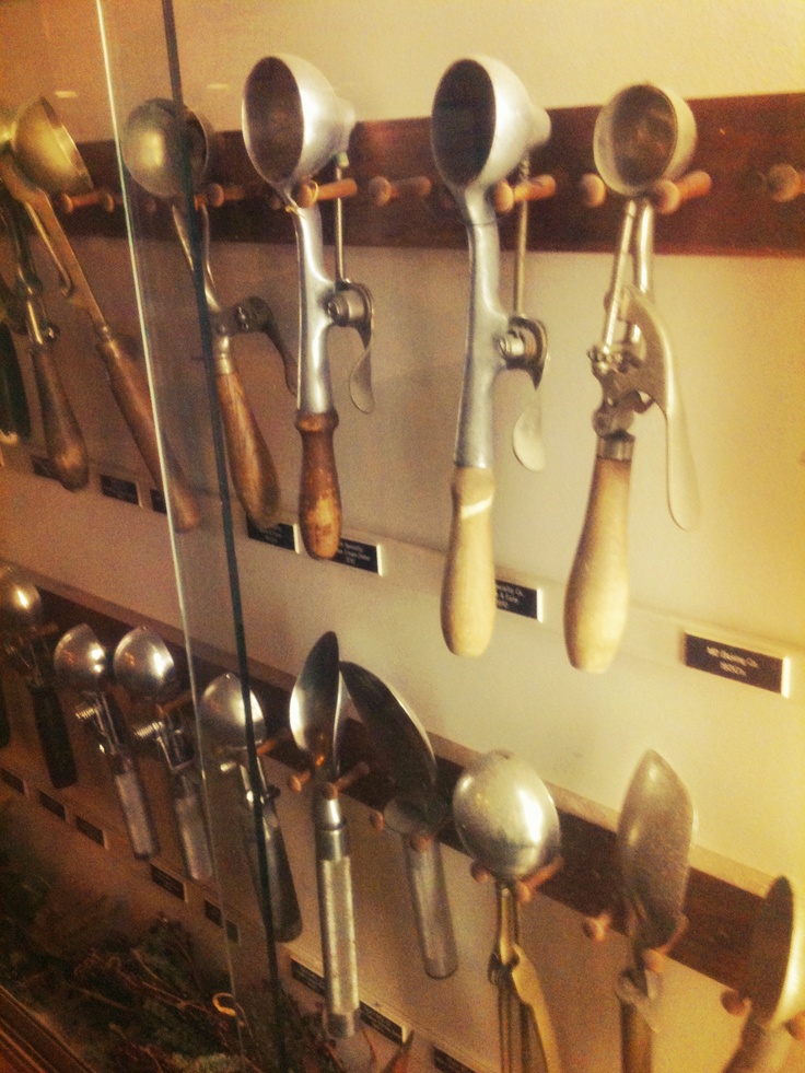 spoons and spatulas are hanging on the wall next to eachother