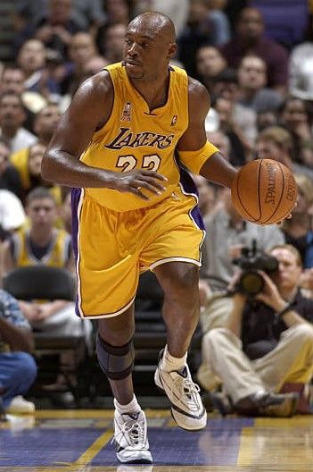 a basketball player dribbling the ball while people watch from the stands in the bleachers