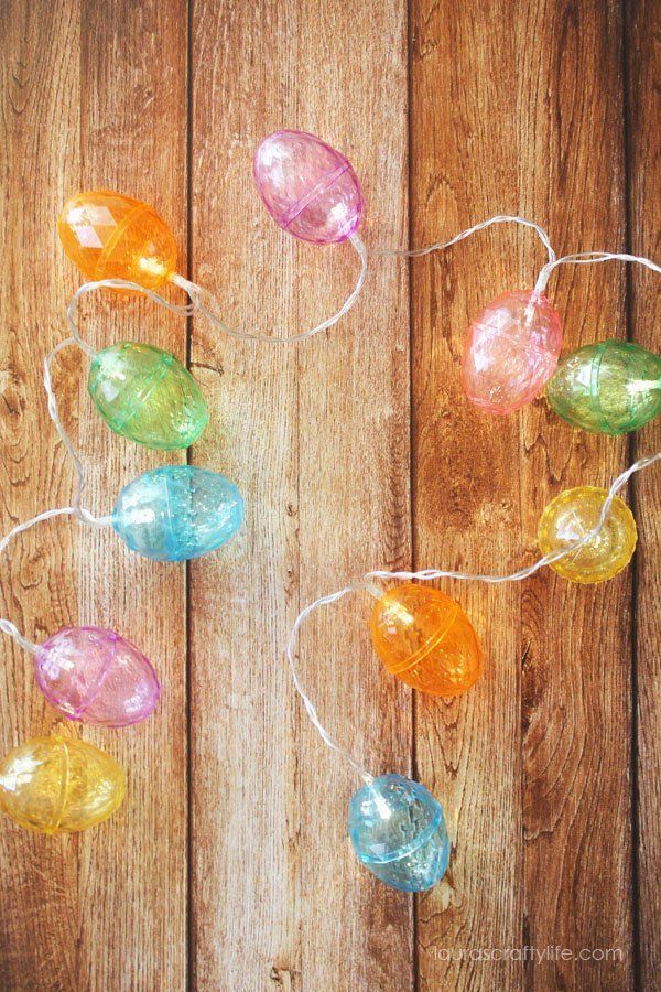 there are many colorful lights hanging on the wooden fence with words that read, light up each egg garland