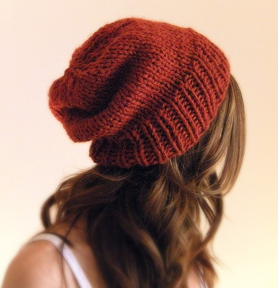 a woman wearing a red knitted beanie with her hair in the back view