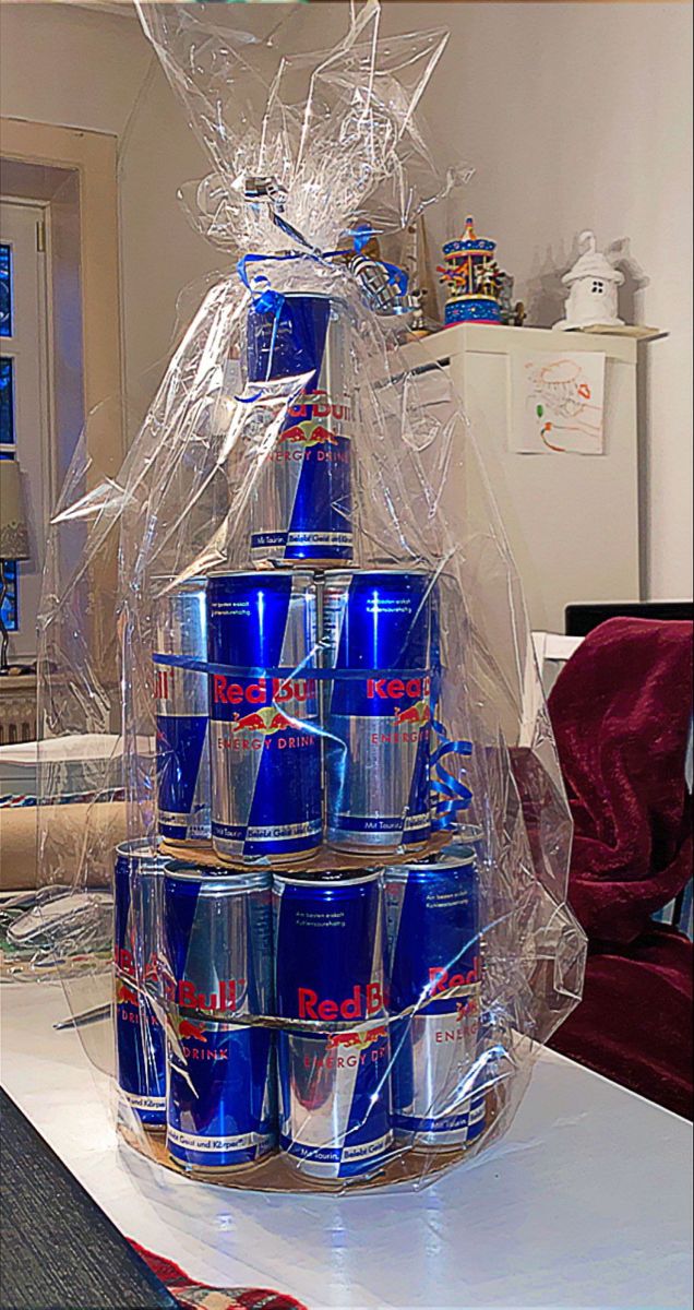 a christmas tree made out of cans on top of a white table with red and blue decorations