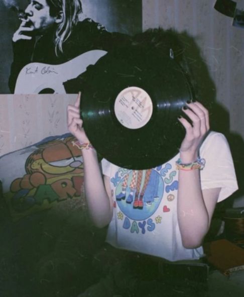 a woman holding up a record in front of her face