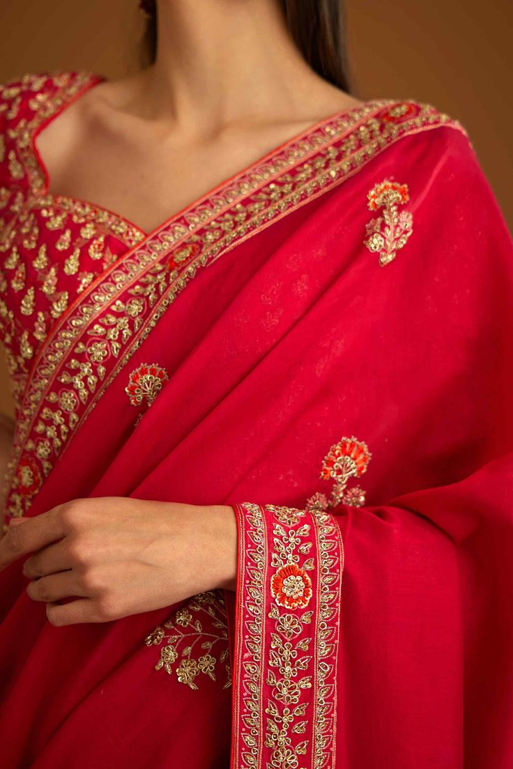 Editor's Note The combination of a red brocade blouse with zardozi embroidery and a silk chanderi sari with zardozi embroidery creates a stunning traditional look. The blouse adds a pop of bold color with intricate detailing, while the sari adds elegance with delicate embroidery. Color: Red Fabric: Silk and chanderi Embroidery details: Zardozi embroidery Components: Sari & blouse Sari length: 6 meters, sari width: 46" inches Occasion: Engagement and wedding guest Disclaimer: Product color may sl Red Brocade Blouse, Blouse Sari, Blouse Yoke, Zardozi Embroidery, Brocade Blouse, Personal Shopping Service, Brocade Blouses, Delicate Embroidery, Casual Tunics