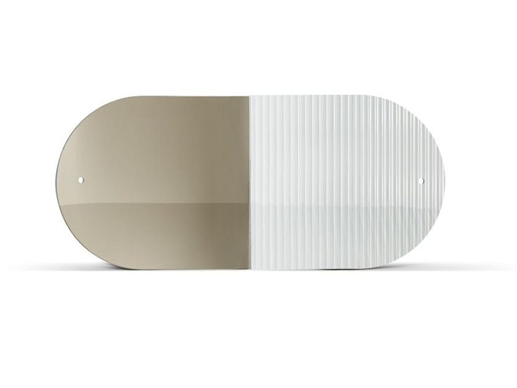 an oval shaped mirror with white and beige stripes on the side, against a white background