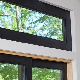 an open window in a white room with black trim and wood frame on the outside