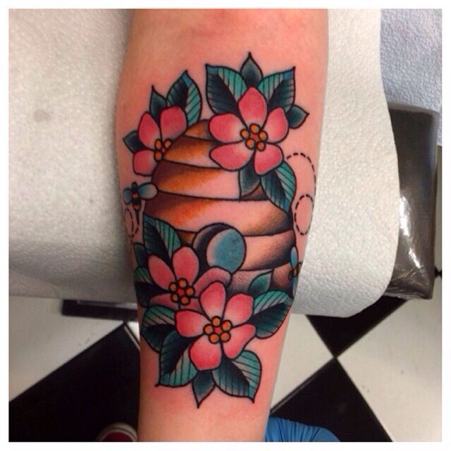 a tattoo with flowers and a cake on it