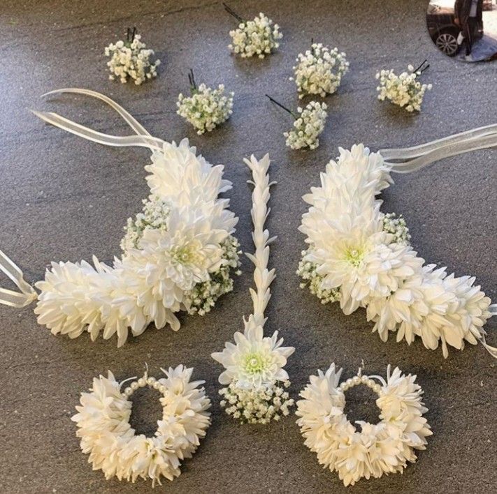 white flowers are arranged on the floor next to each other and tied together with ribbons