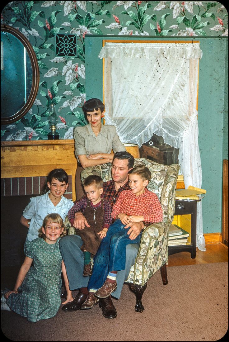 an old photo of a family sitting in a chair