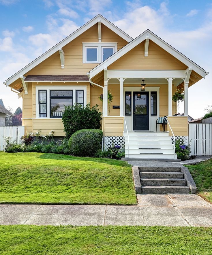 a yellow house with steps leading to the front door