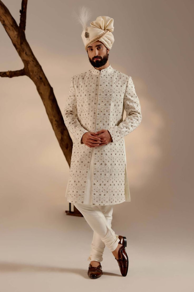 Editor's Note Featuring our infamous kashmiri jamawar embroidered sherwani in dirty ivory color with floral design details. The piece is then highlighted with dabka and zari. Paired with a matching ladakhi pashmina shawl and safa. Fabric: Linen silk Color: White Components: Sherwani, kurta, churidar, pashmina shawl and safa Occasion: Groom Fit: Regular Note: Product colour may slightly vary due to photographic lighting sources Care: Dry clean only About the Designer After establishing himself as Off White Naqshi Bandhgala For Festive Occasions, Off White Bandhgala With Naqshi For Festive Occasions, Long Sleeve Raw Silk Sherwani With Chikankari Embroidery, Cream Sherwani With Chikankari Embroidery And Long Sleeves, Cream Long Sleeve Sherwani With Chikankari Embroidery, Off White Naqshi Bandhgala, Formal Beige Sherwani With Chikankari Embroidery, Fitted Off White Kurta With Naqshi, Festive Off White Bandhgala With Naqshi