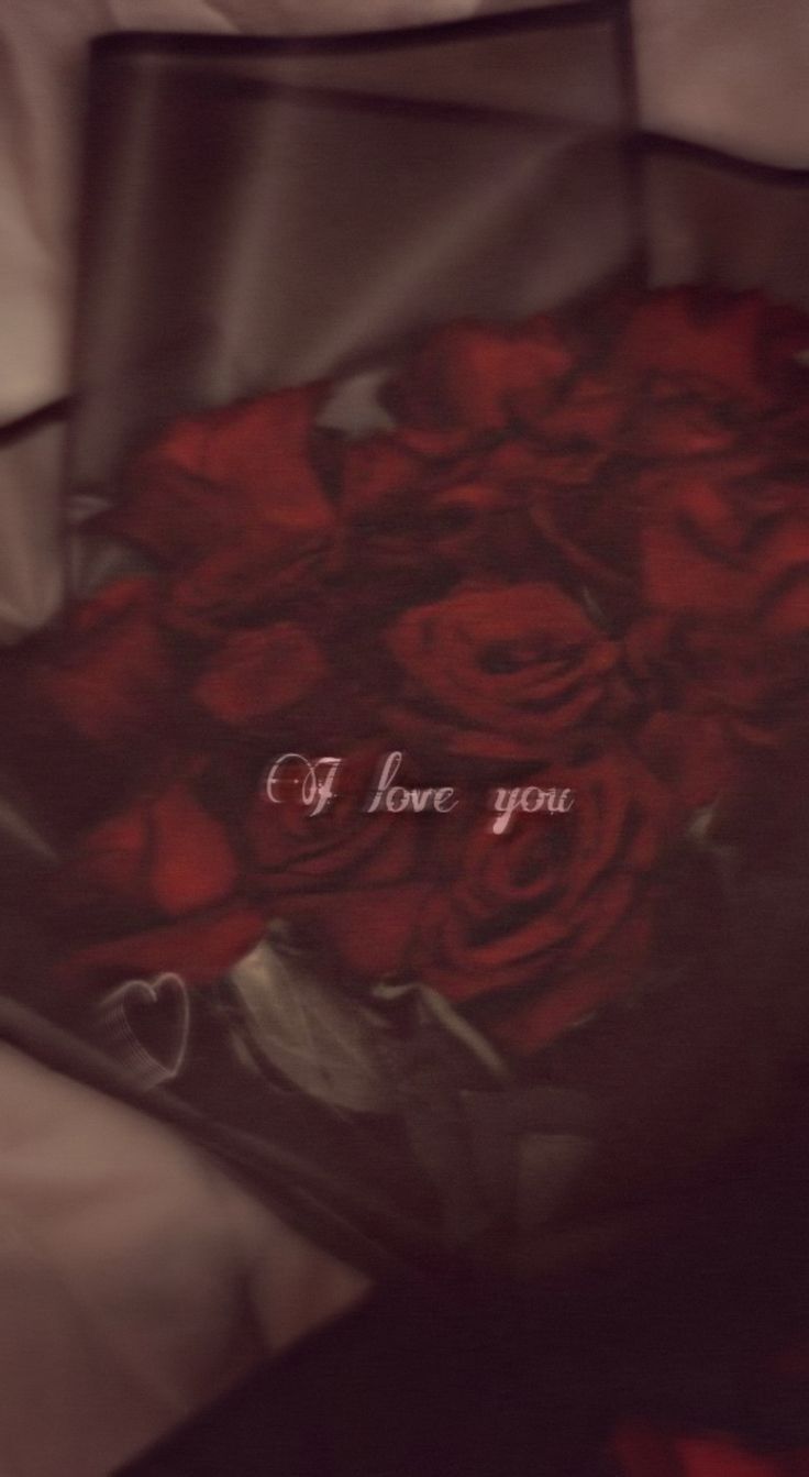 a bouquet of red roses with the words i love you written on it in cursive writing