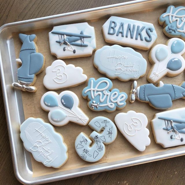 a cookie tray filled with lots of different shaped cookies on top of a wooden table