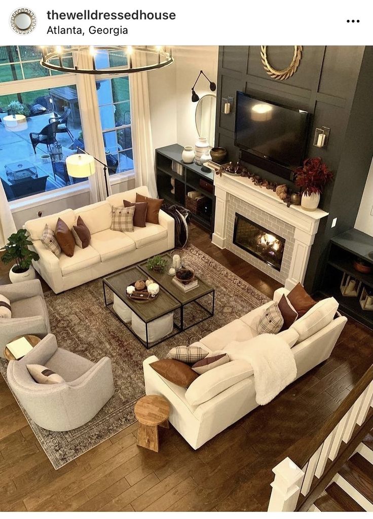 a living room filled with furniture and a flat screen tv mounted to a wall above a fire place