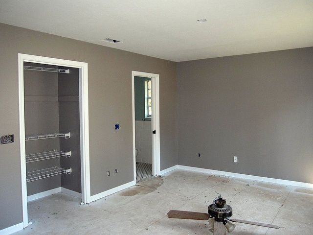 an empty room with two closets and one door open to the other side that is being painted gray