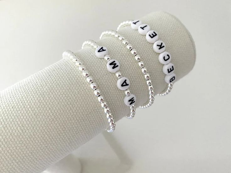 one name bracelet made with 4mm sterling silver beads bracelets are made on a durable stretch elastic cord please refer to our sizing guide before purchasing White Stretch Bracelet With Letter Beads For Personalized Gift, Personalized White Stretch Bracelet With Letter Beads, Classic White Name Bracelet As Gift, Customizable White Bracelets For Friendship, Flexible White Beaded Friendship Bracelet, Adjustable White Name Bracelet With Custom Text, White Personalized Stretch Bracelet With Round Beads, White Minimalist Sterling Silver Beaded Bracelet, Minimalist White Sterling Silver Beaded Bracelet