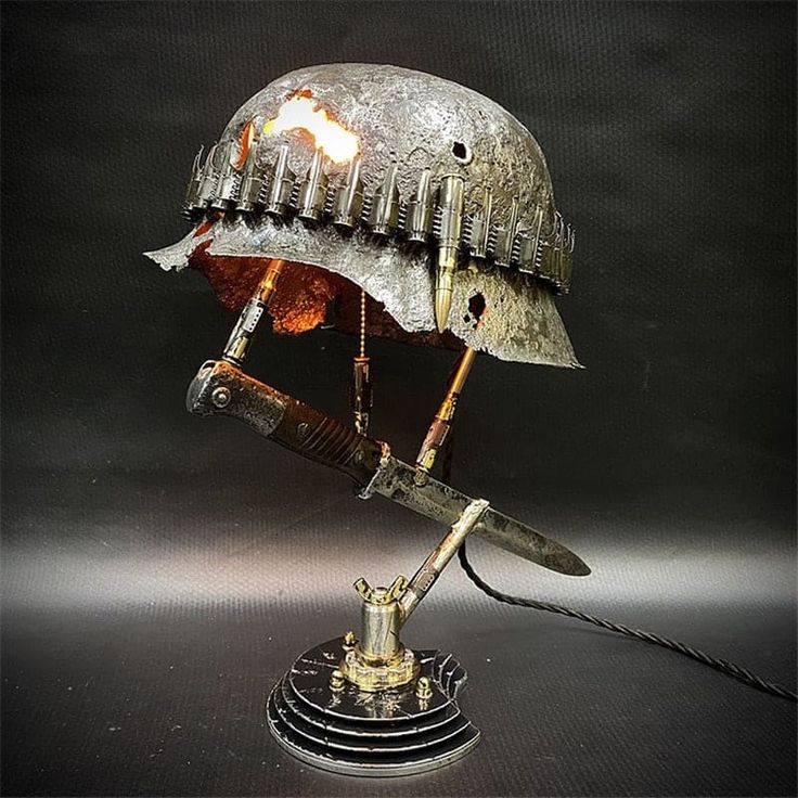 an old metal helmet is on top of a stand with a light coming out of it