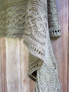 a knitted sweater hanging on the side of a wooden door