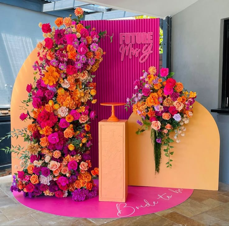 two tall vases filled with colorful flowers sitting on top of a pink and yellow floor