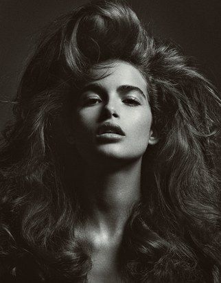 a black and white photo of a woman with her hair blowing in the wind,