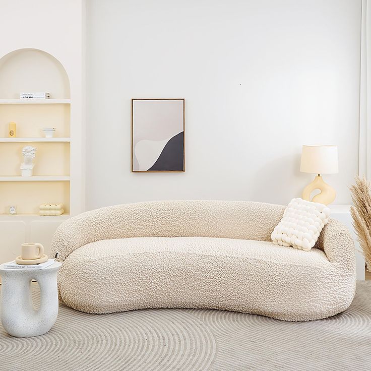 a living room with a couch, coffee table and bookshelf in the corner